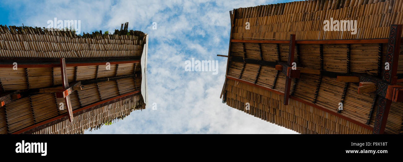 Two rooftops of traditional houses in Tana Toraja under blue cloudy sky Stock Photo