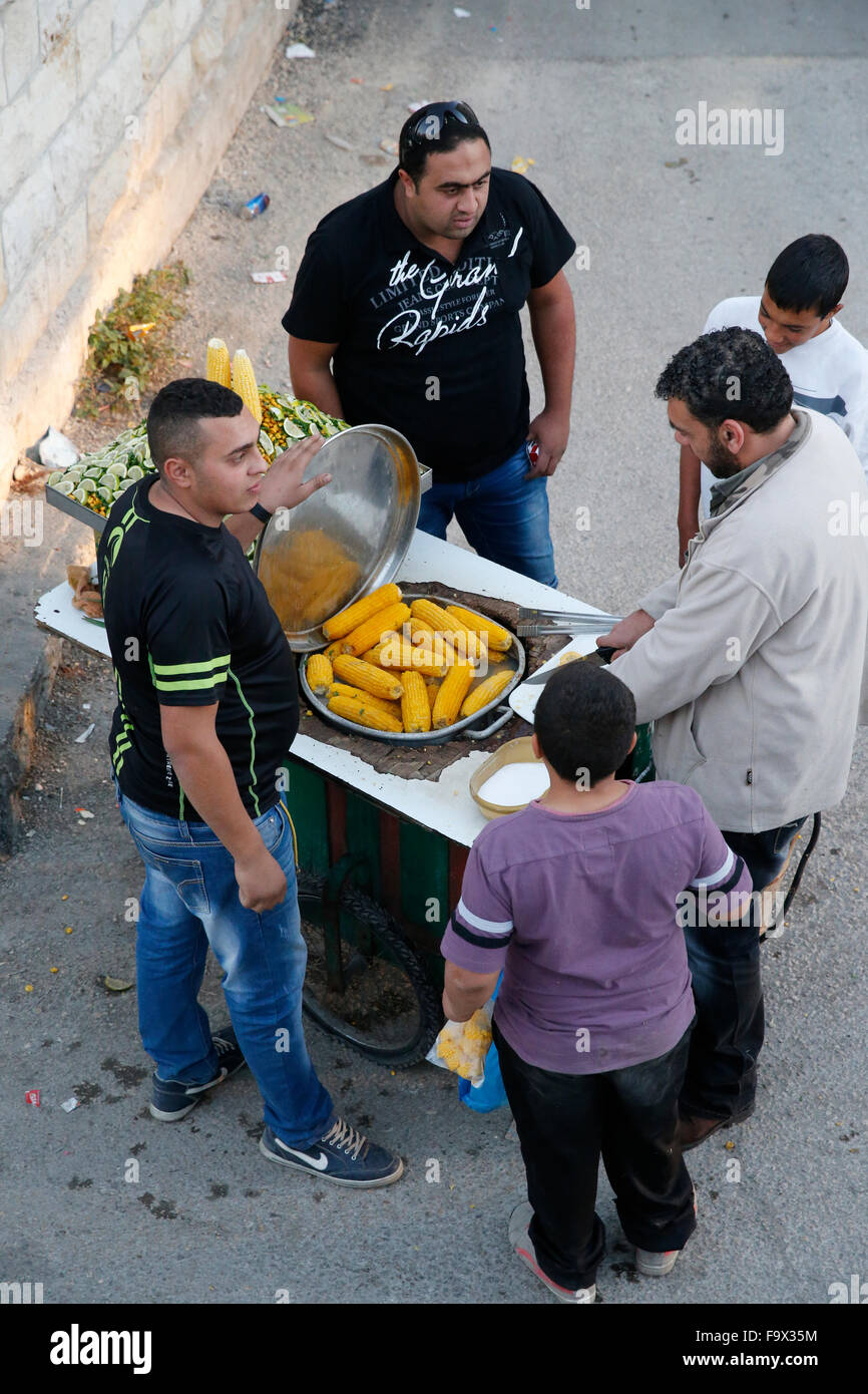 Man selling corn on the cob with friends and clients. Stock Photo