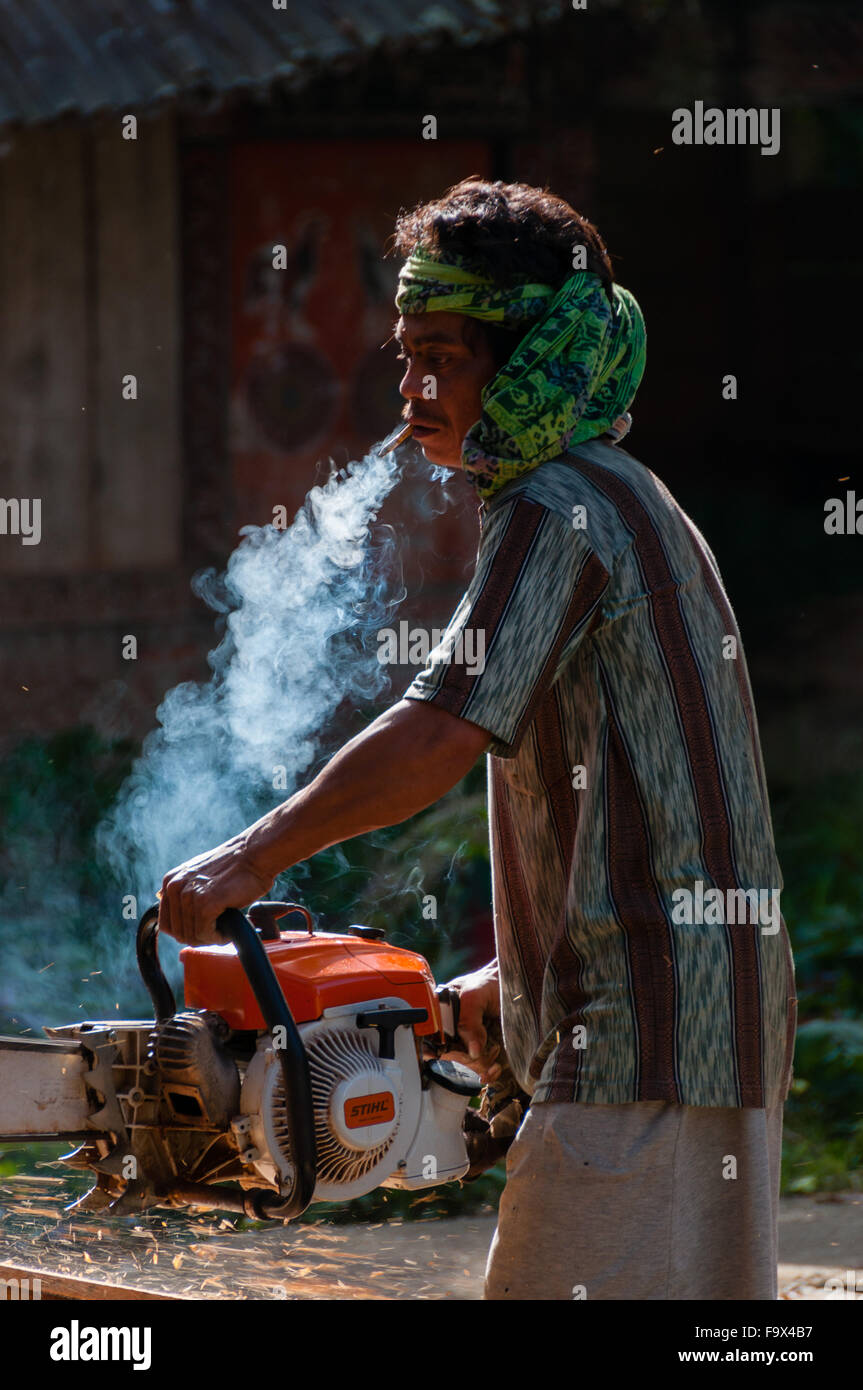 Asian Man with bandana smoking and using his chainsaw Stock Photo