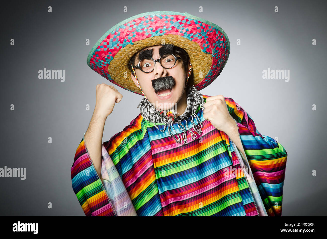 Man in vivid mexican poncho against gray Stock Photo - Alamy