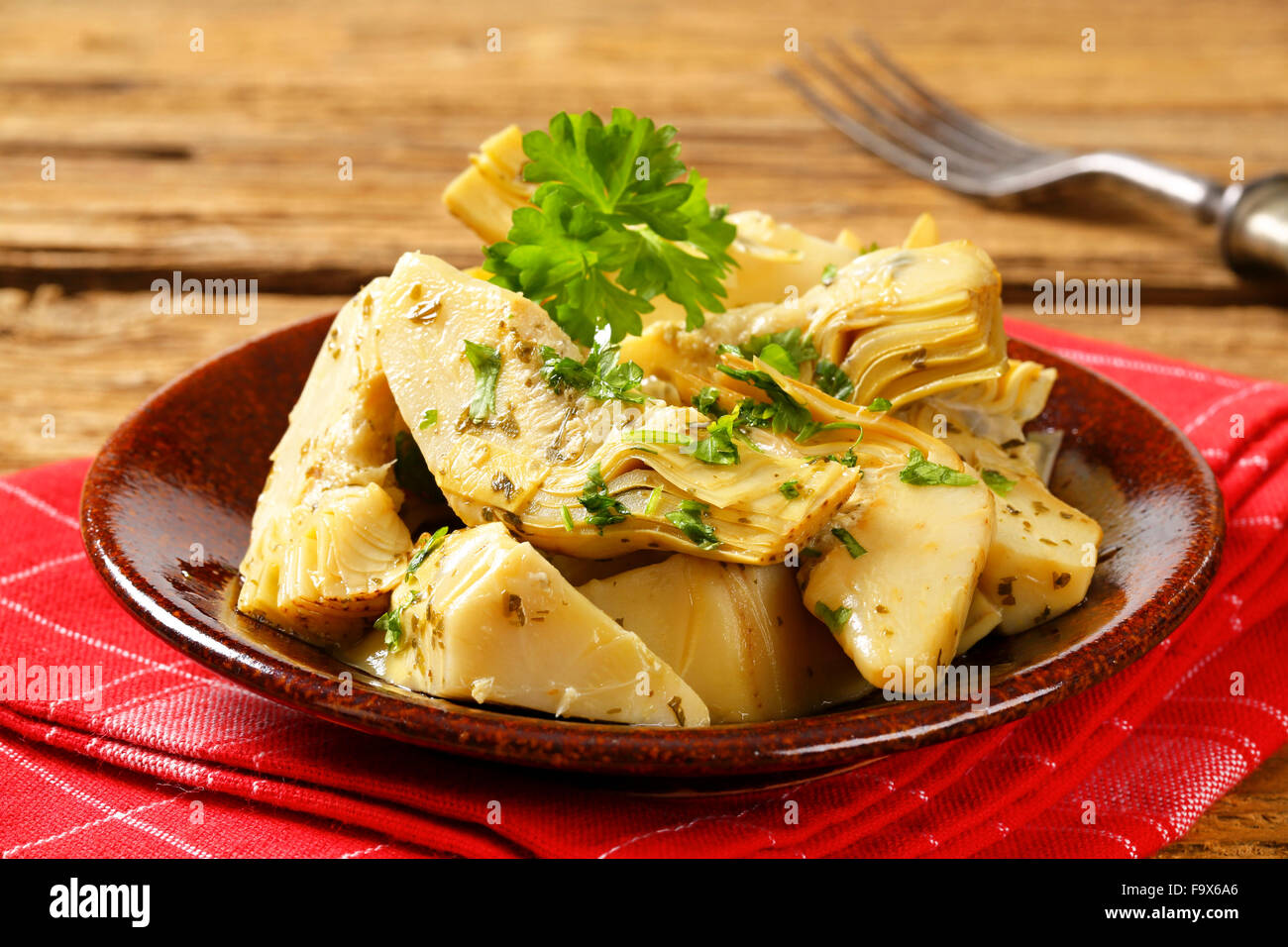 Artichoke hearts dressed in oil and herb marinade Stock Photo Alamy