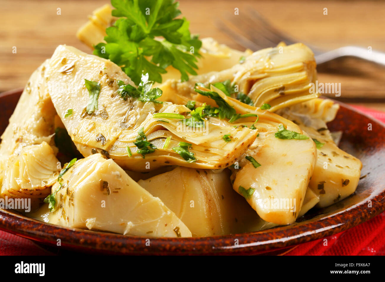 Artichoke hearts dressed in oil and herb marinade Stock Photo Alamy