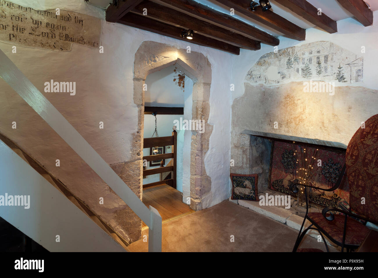 Historic religious text and mural exposed and preserved in an old Cotswold cottage, Gloucestershire, England, UK Stock Photo