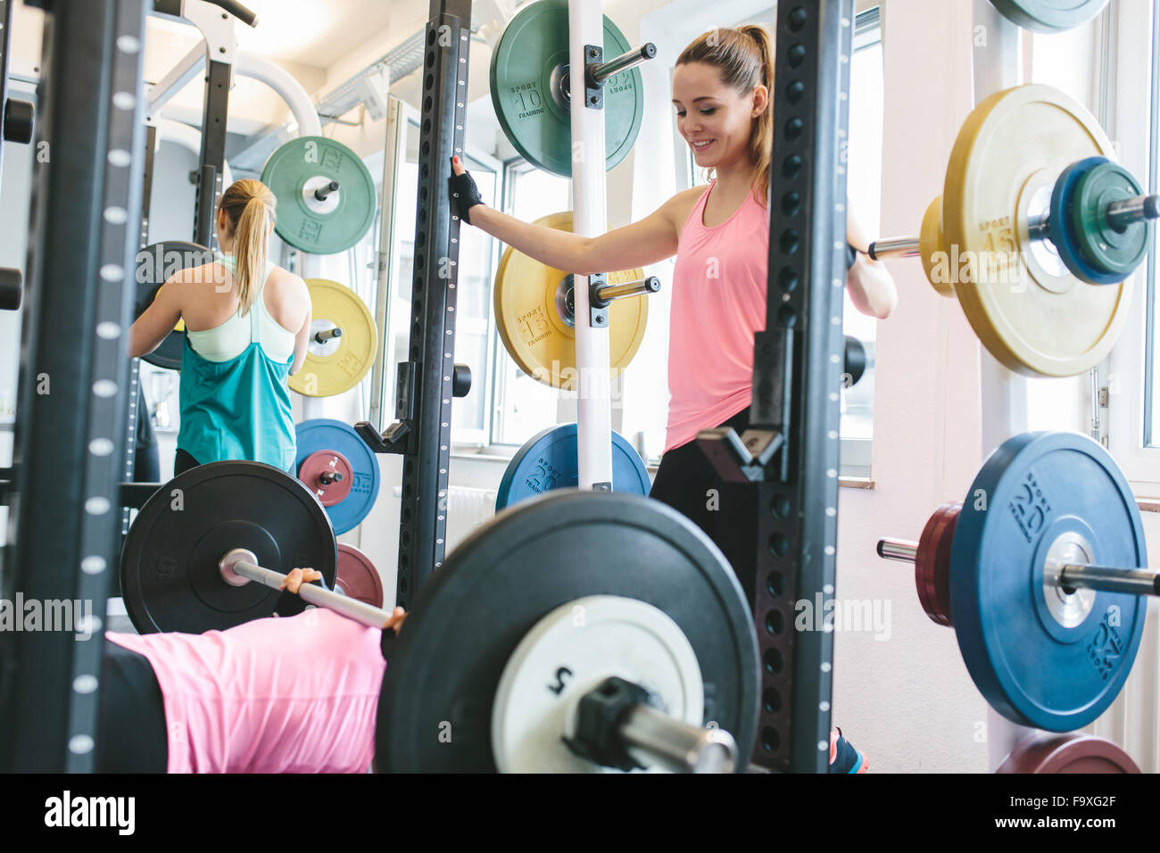 Two women doing barbell bench presses in a power rack Stock Photo Alamy