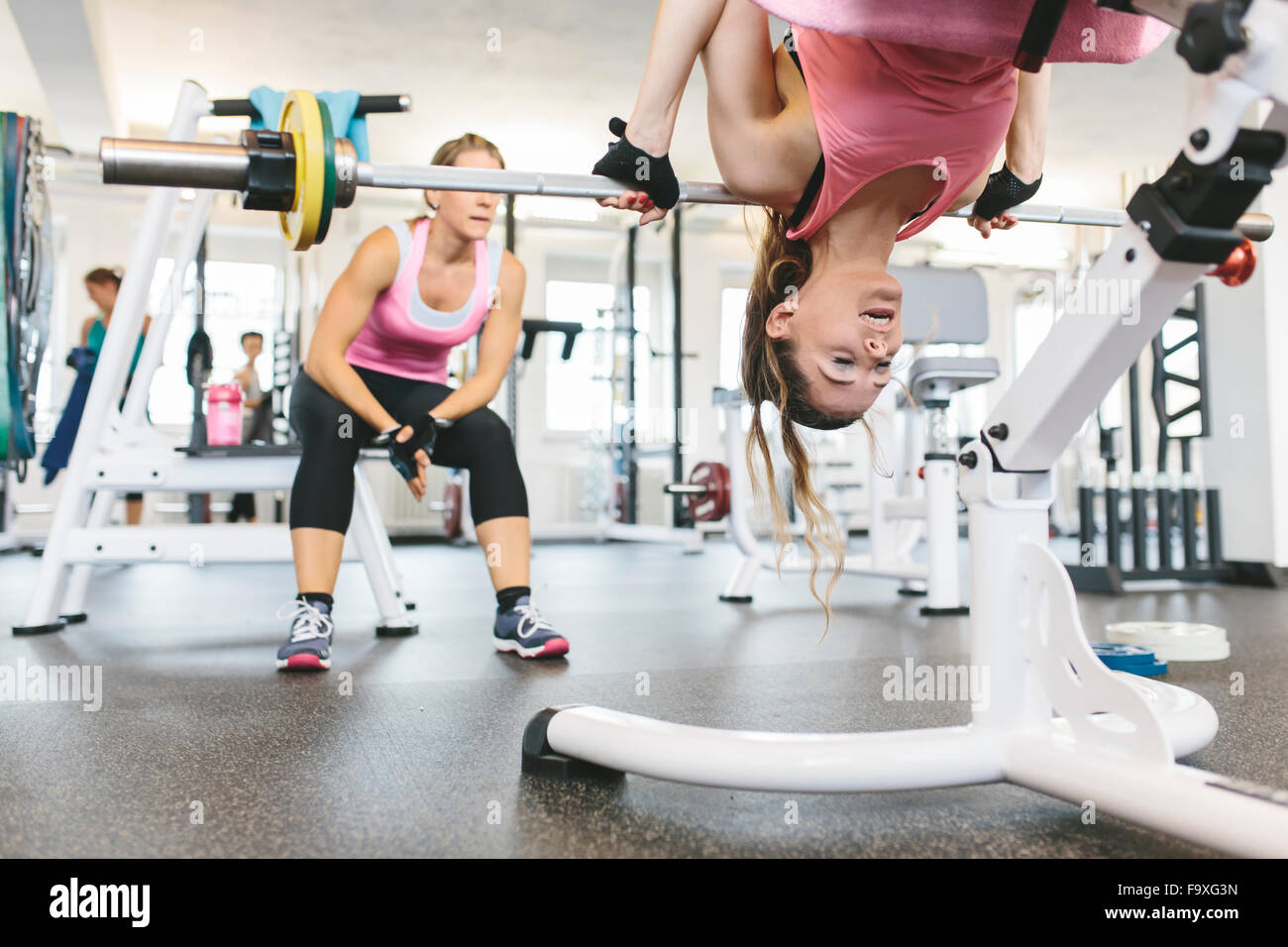 Woman doing weighted back extensions in gym Stock Photo
