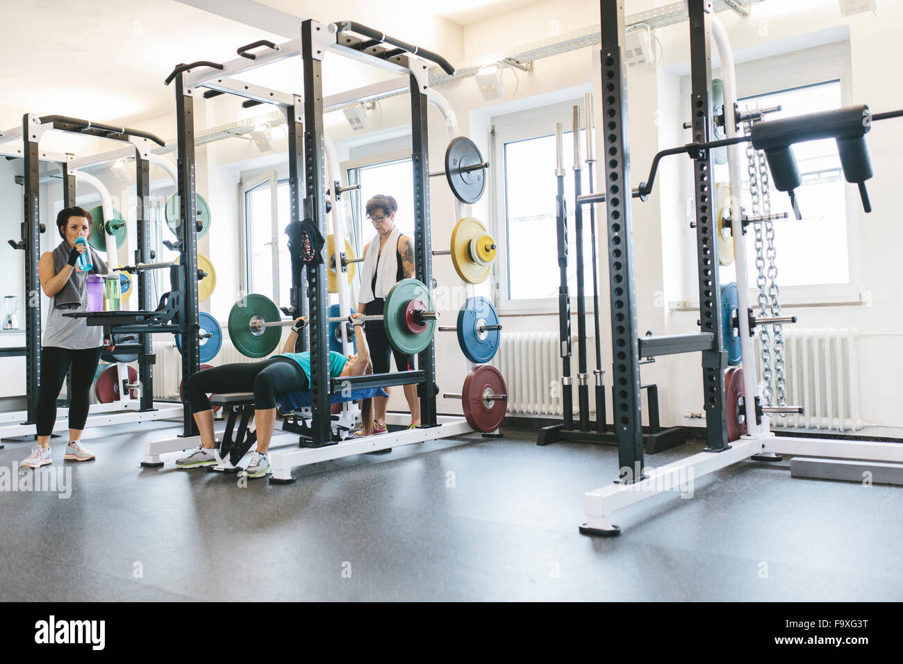 Three women doing barbell bench presses in a power rack Stock Photo Alamy