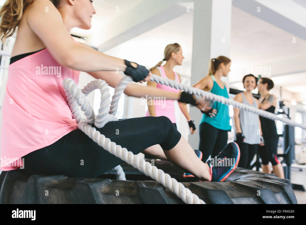 Woman pulling a sled on a rope in gym Stock Photo