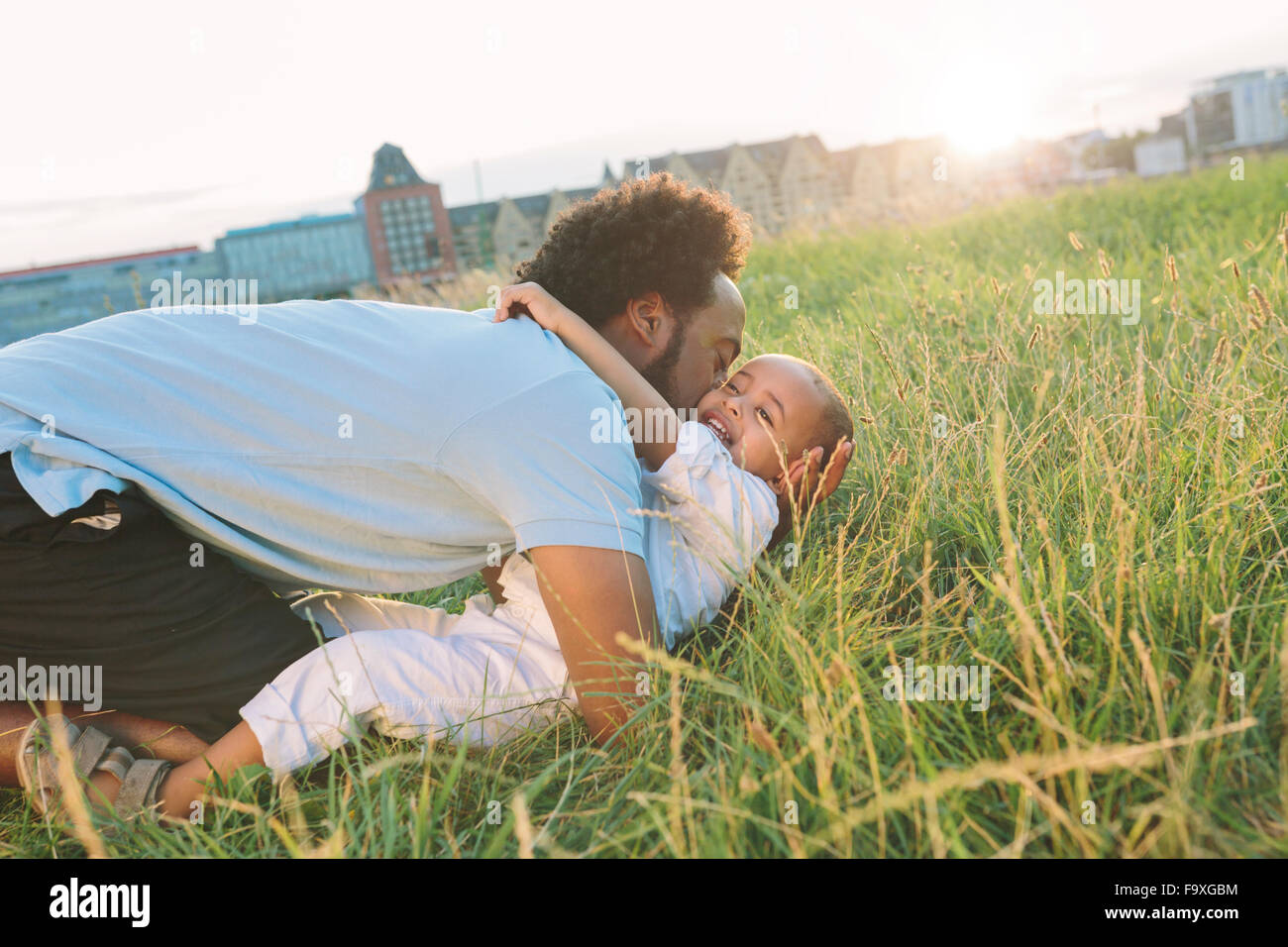 Germany, Cologne, playful father with son in field Stock Photo