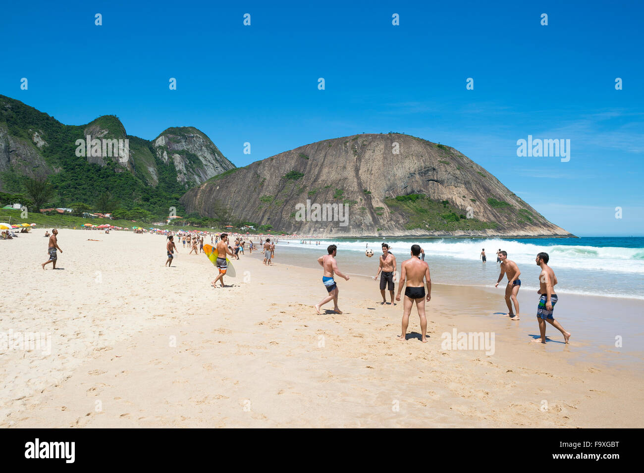 RIO DE JANEIRO, BRAZIL - OCTOBER 31, 2015: Young Brazilians play beach football on the shore of Itacoatiara Beach. Stock Photo