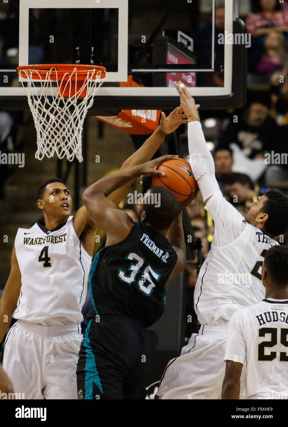 Winston-Salem, NC, USA. 18th Dec, 2015. Marcus Freeman (35) of the Coastal Carolina Chanticleers goes up against Doral Moore (4) and Devin Thomas (2) of the Wake Forest Demon Deacons in the NCAA Basketball match-up between the Coastal Carolina Chanticleers and the Wake Forest Demon Deacons at Lawerence Joel Veteran Memorial Coliseum in Winston-Salem, NC. Scott Kinser/CSM/Alamy Live News Stock Photo