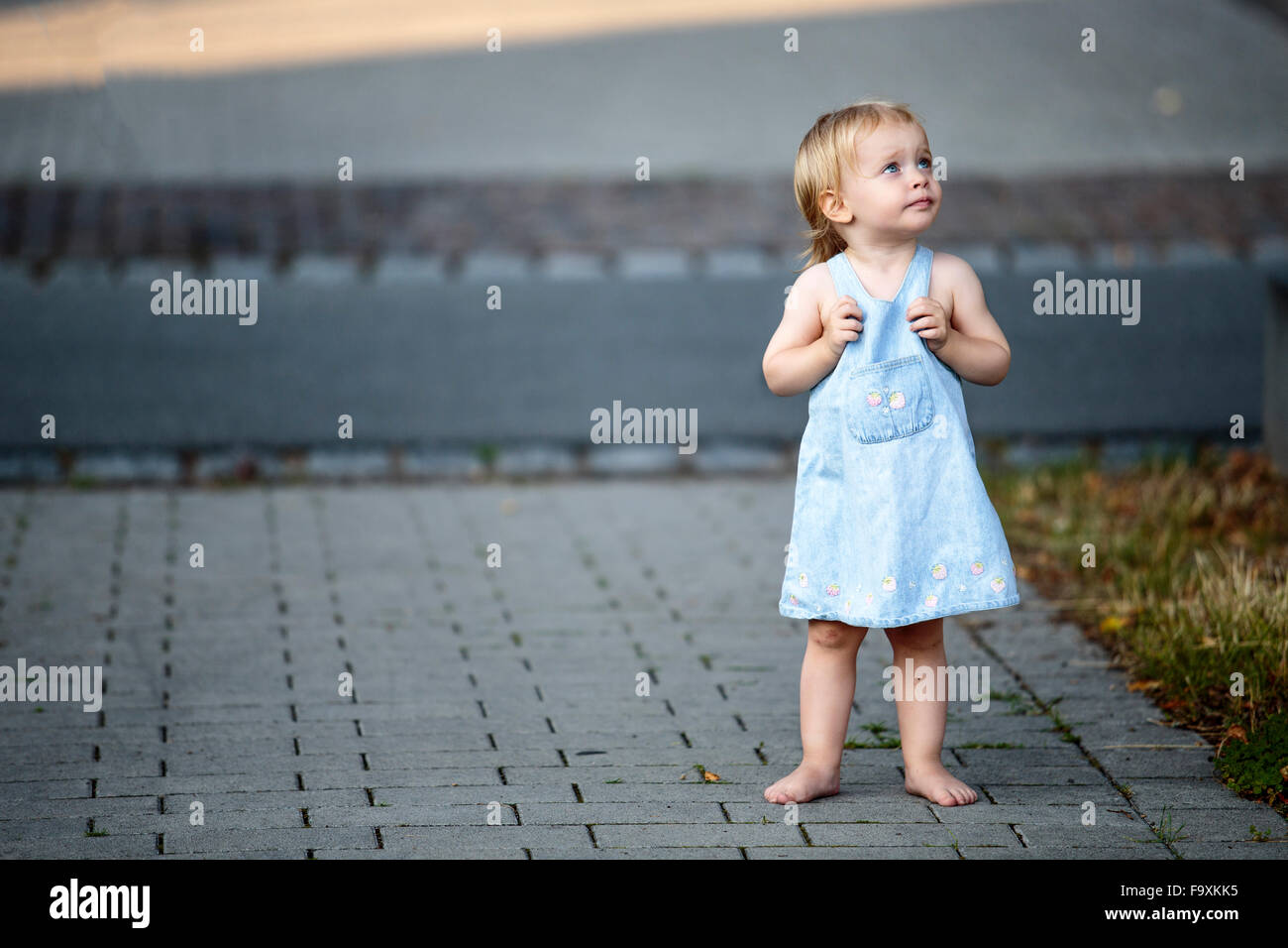 https://c8.alamy.com/comp/F9XKK5/barefoot-blond-little-girl-standing-on-pavement-looking-up-F9XKK5.jpg