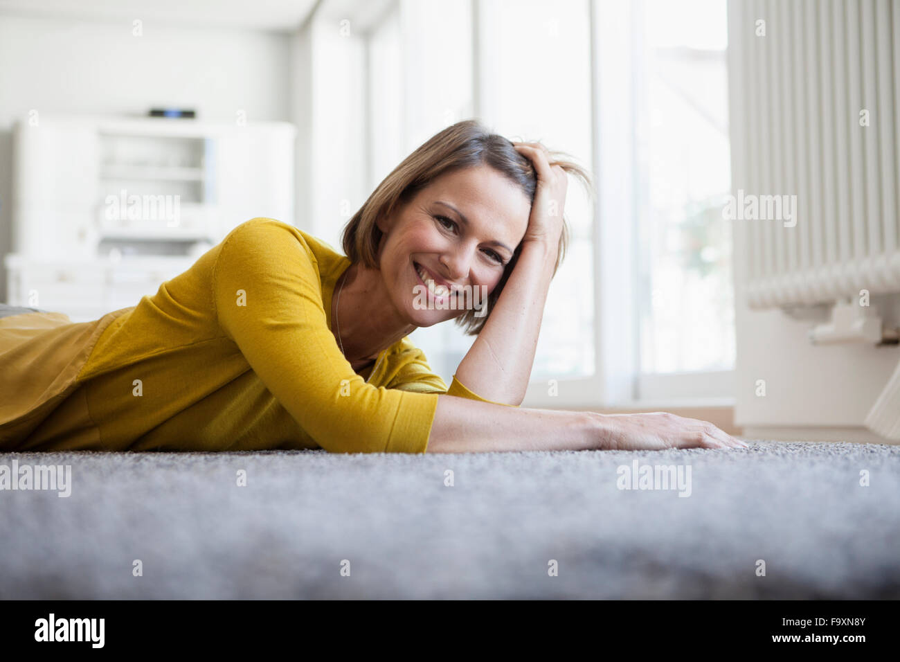 Portrait of relaxed woman at home lying on floor Stock Photo - Alamy