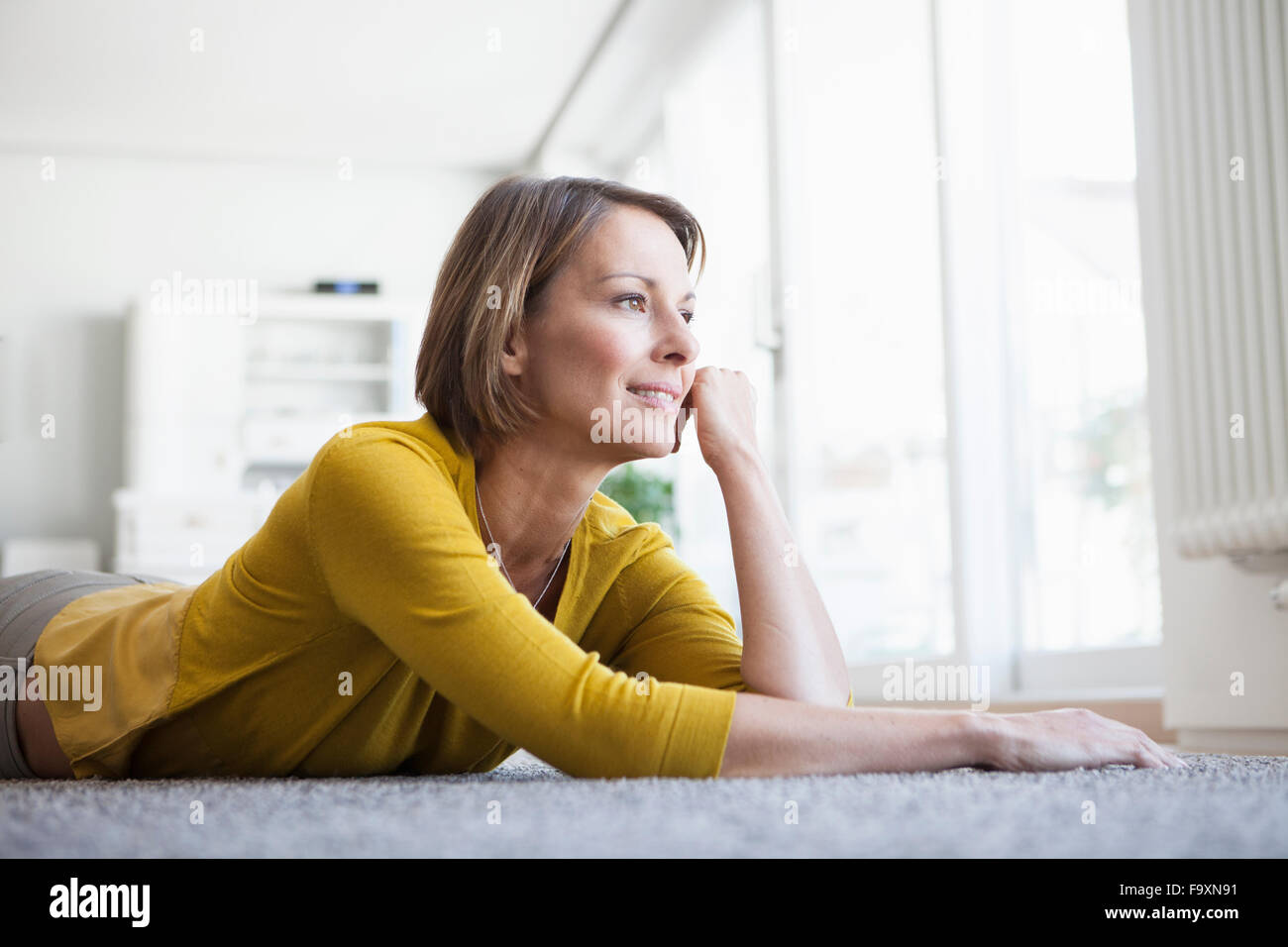 Relaxed woman at home lying on floor Stock Photo - Alamy