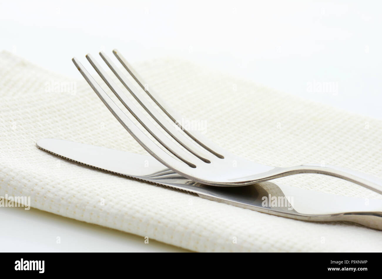 Dinner knife and fork on white napkin Stock Photo Alamy