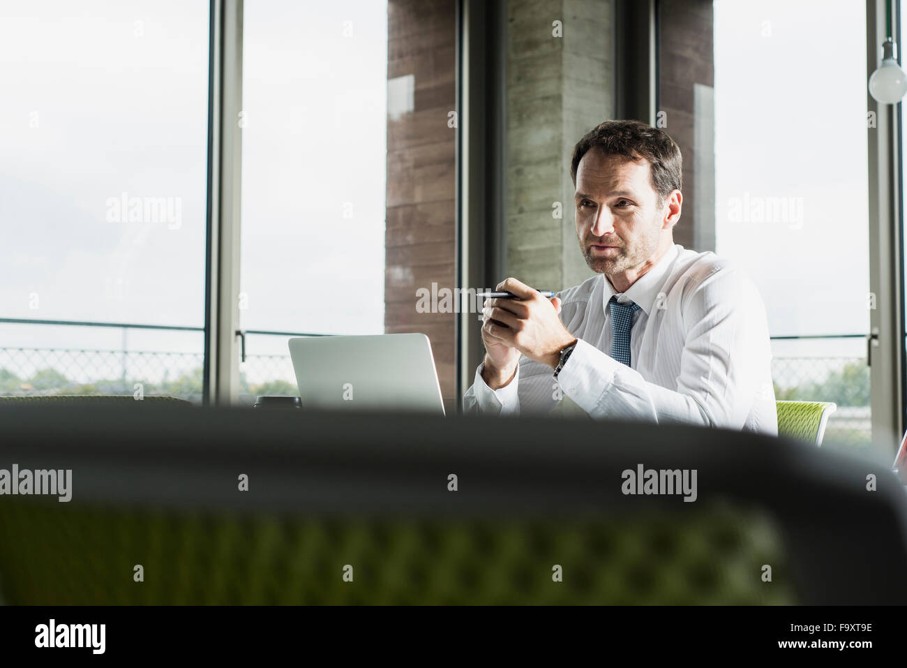 Portrait of pensive businessman at his desk in the office Stock Photo