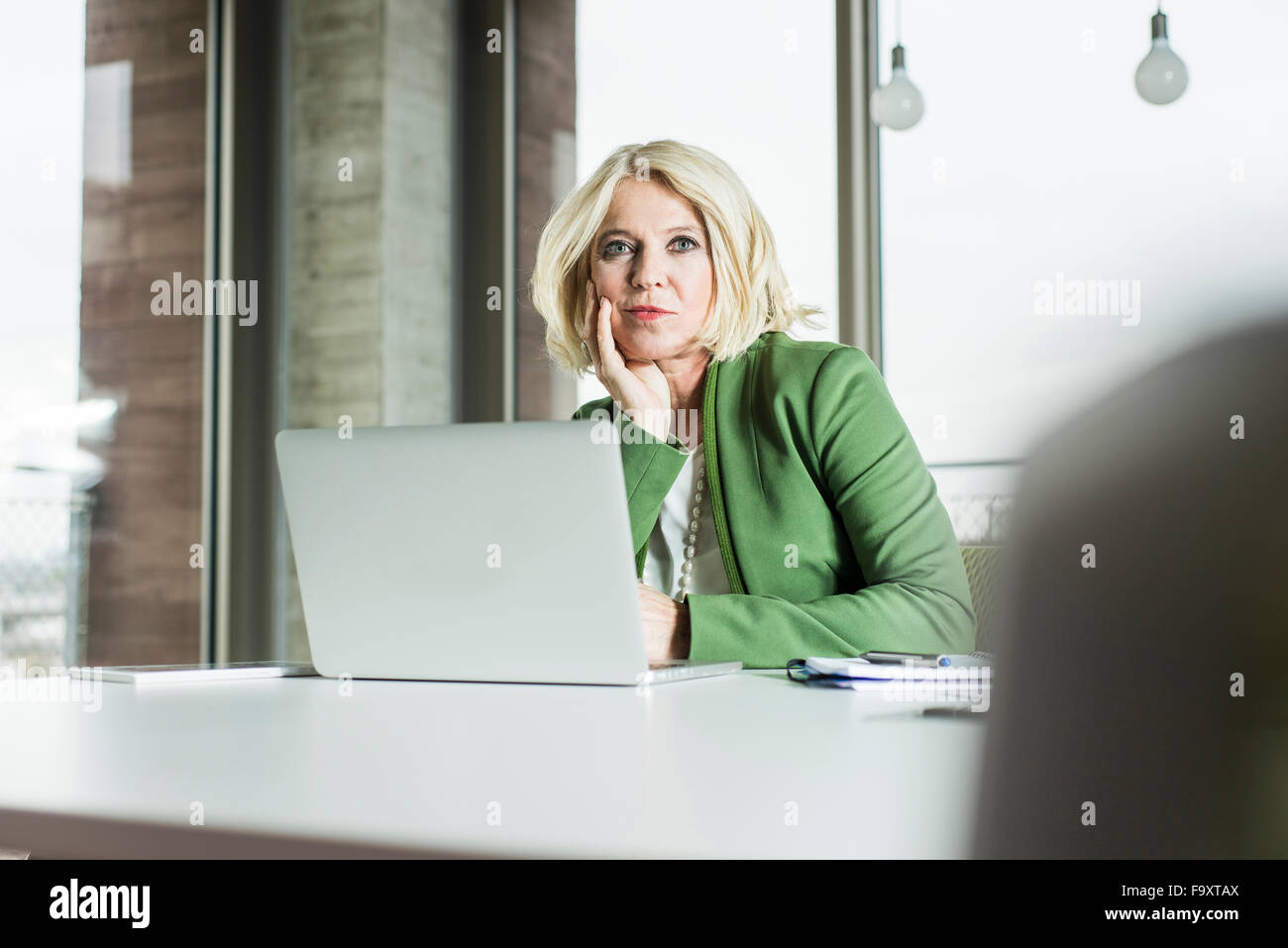 Portrait of thinking businesswoman at her desk in the office Stock Photo
