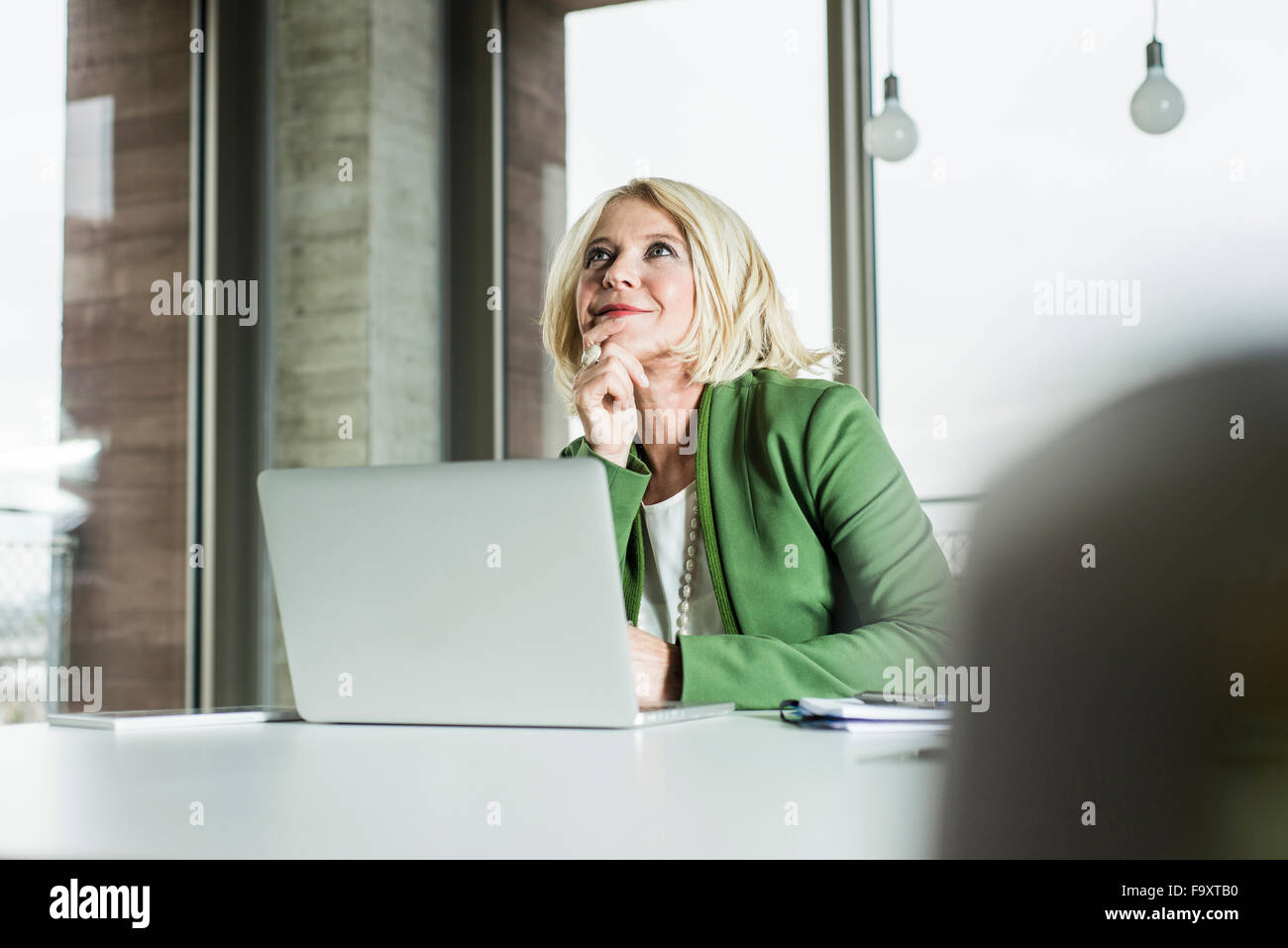 Portrait of thinking businesswoman at her desk in the office Stock Photo