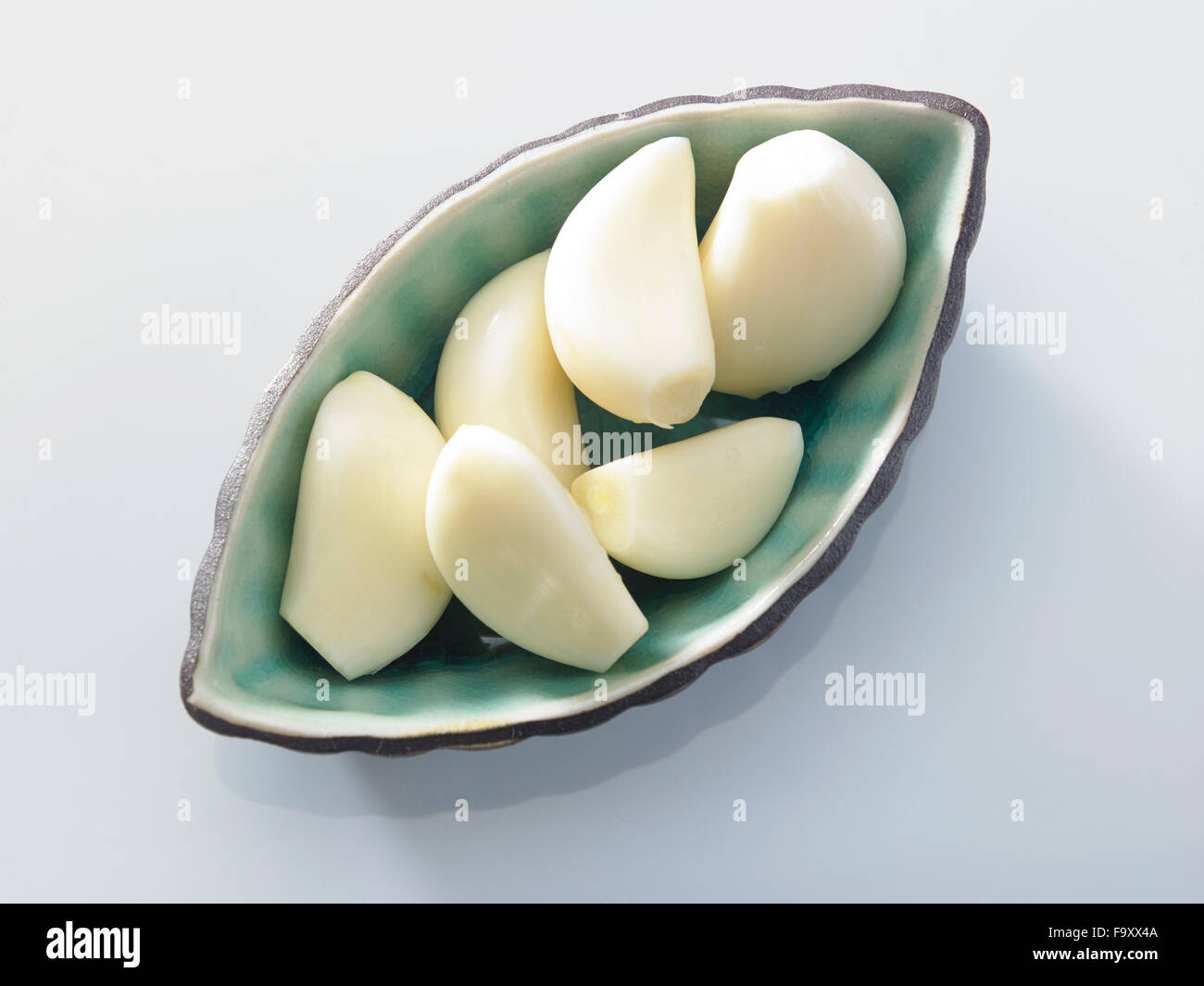 Fresh peeled garlic in a bowl, isolated on white background Stock Photo ...