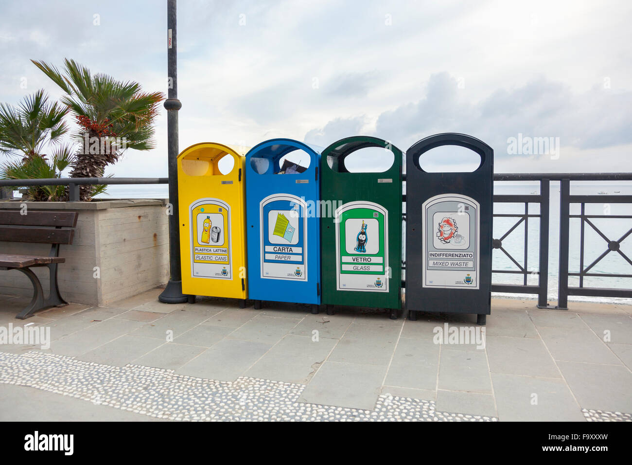 Four colour-coded recycling bins on a beach promenade in Italy (Monterosso Al Mare, Italy) Stock Photo