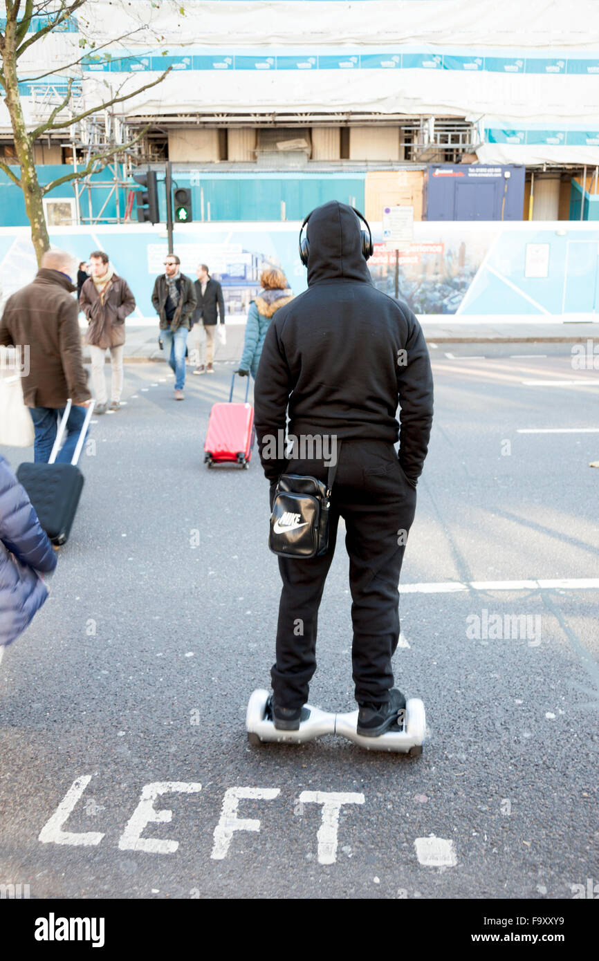 Teenager on a hoverboard crossing the road in London, UK Stock Photo