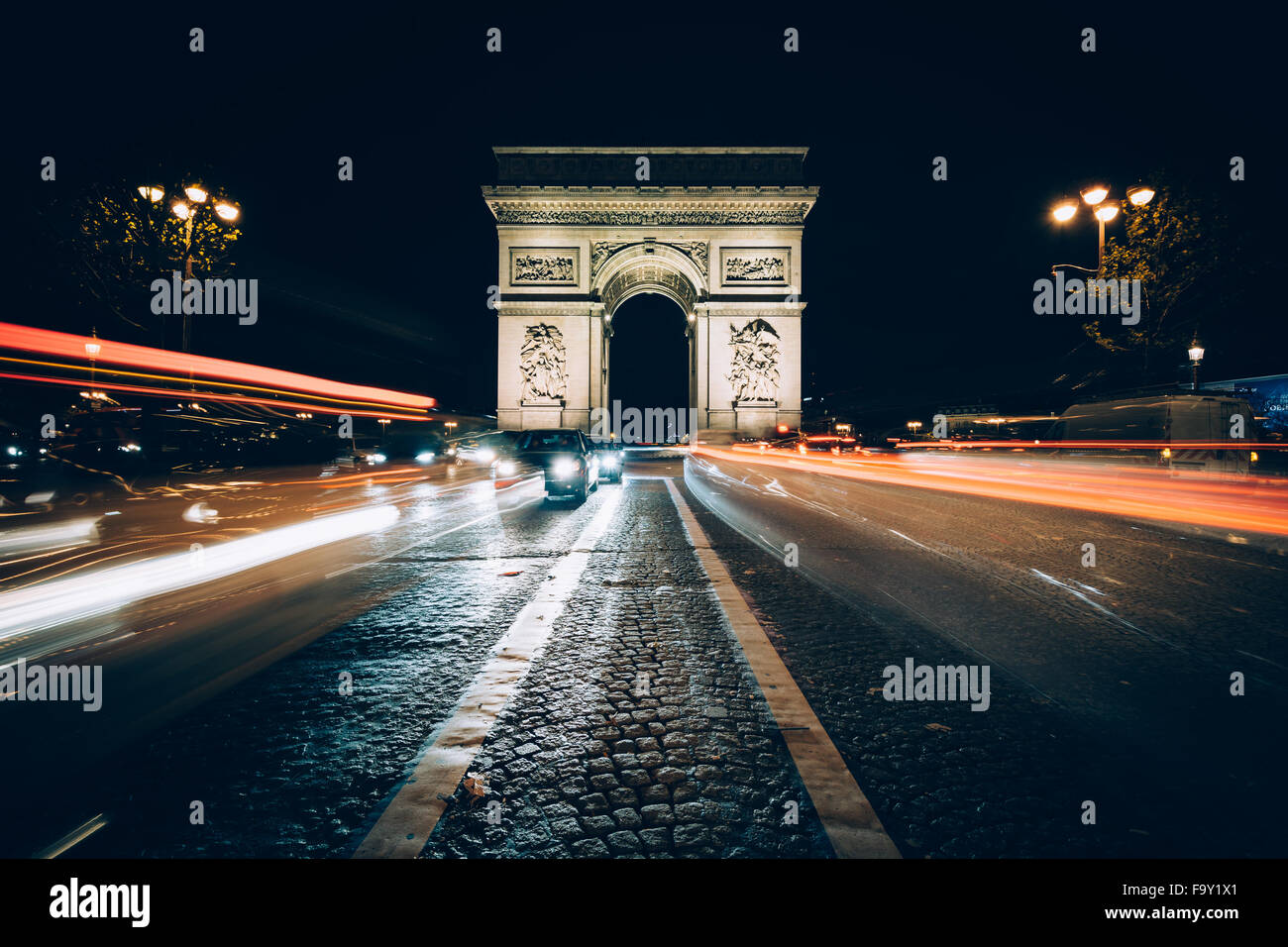 Traffic on Avenue des Champs-Élysées and the Arc de Triomphe at night in Paris, France. Stock Photo