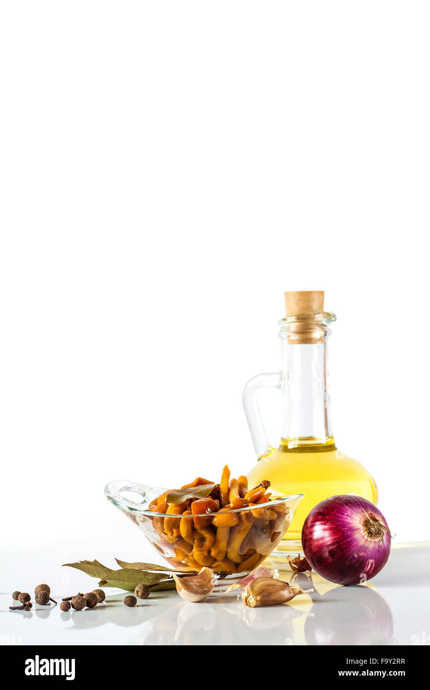 Olive oil and delicious marinated mushrooms in glass bowl, red onion