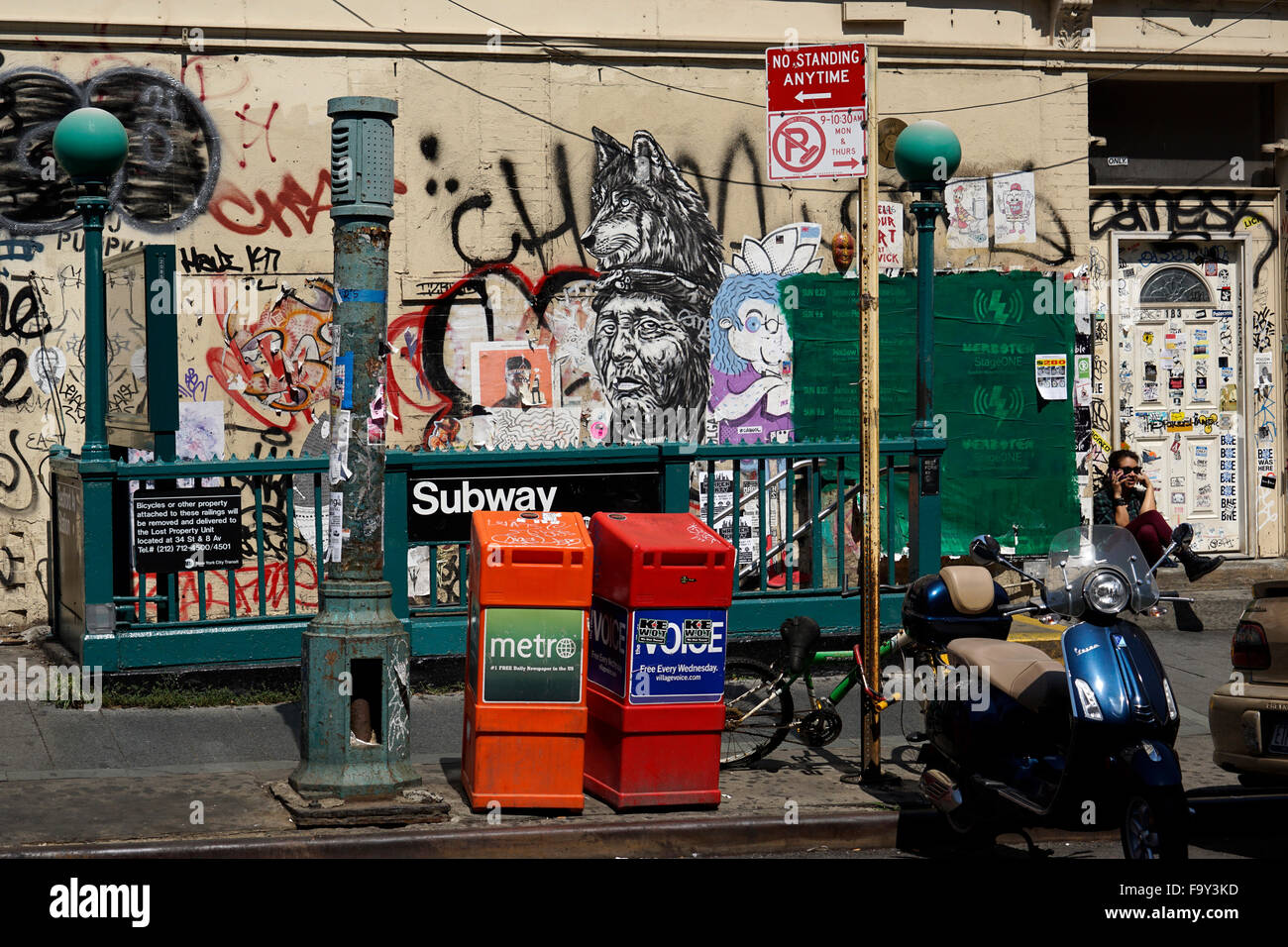 New York City subway station with graffiti in the background and parked bike, scooter and newspaper stand in the foreground USA Stock Photo