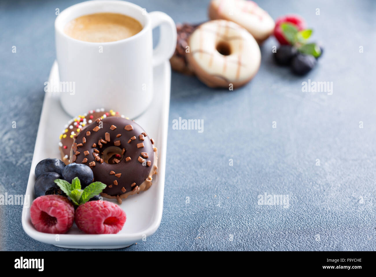 Small glazed mini donuts and coffee in an espresso cup Stock Photo