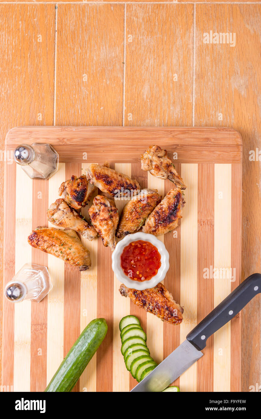 homemade grilled chicken wings on bamboo cutting board with  Thai chill sweet sauce top angel view Stock Photo