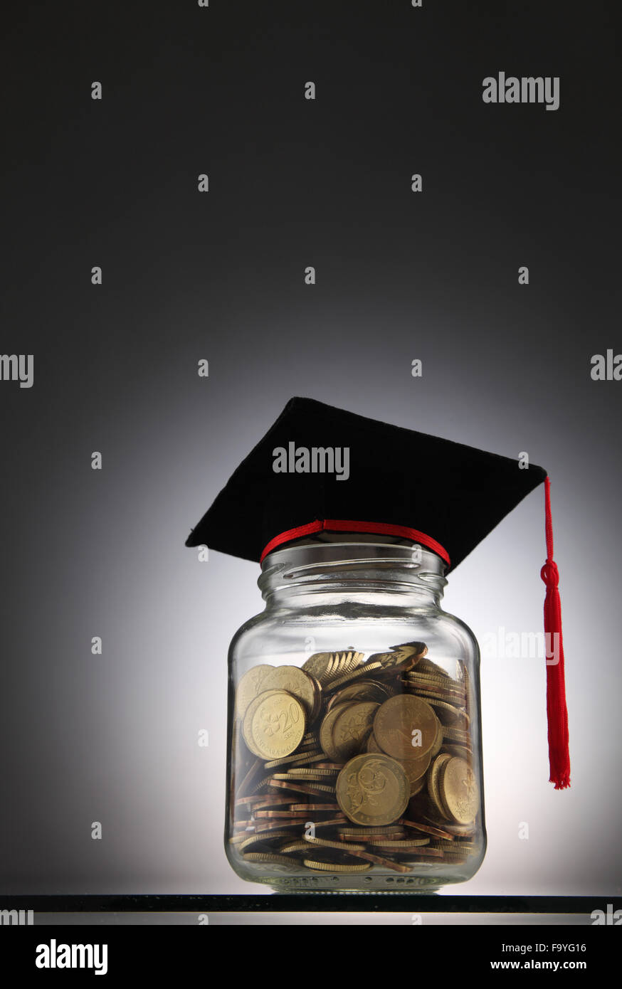 Bottle of cash with graduation cap Stock Photo Alamy
