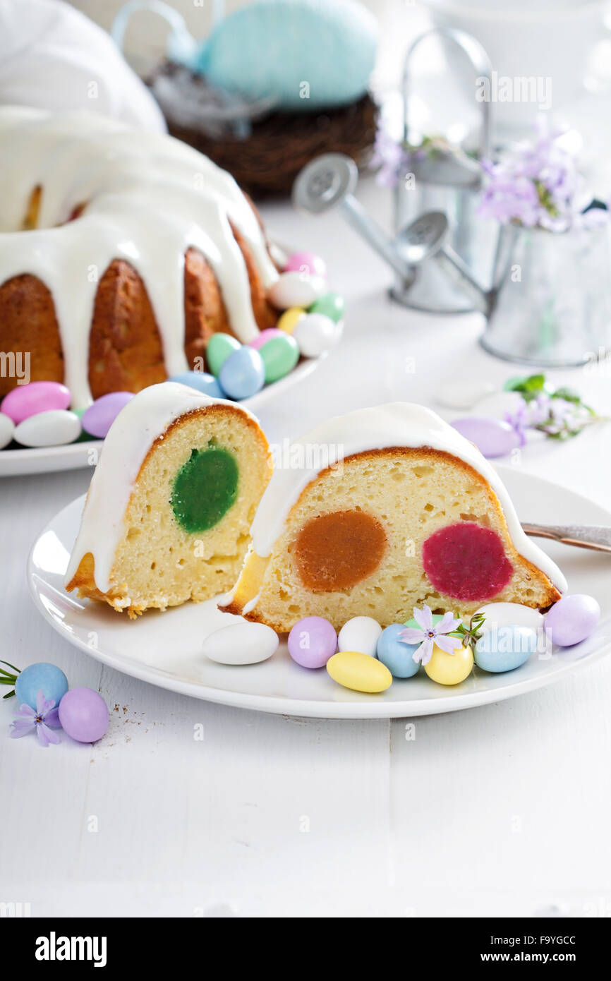 Easter cake with colorful filling, glaze and decorative egg candies Stock Photo