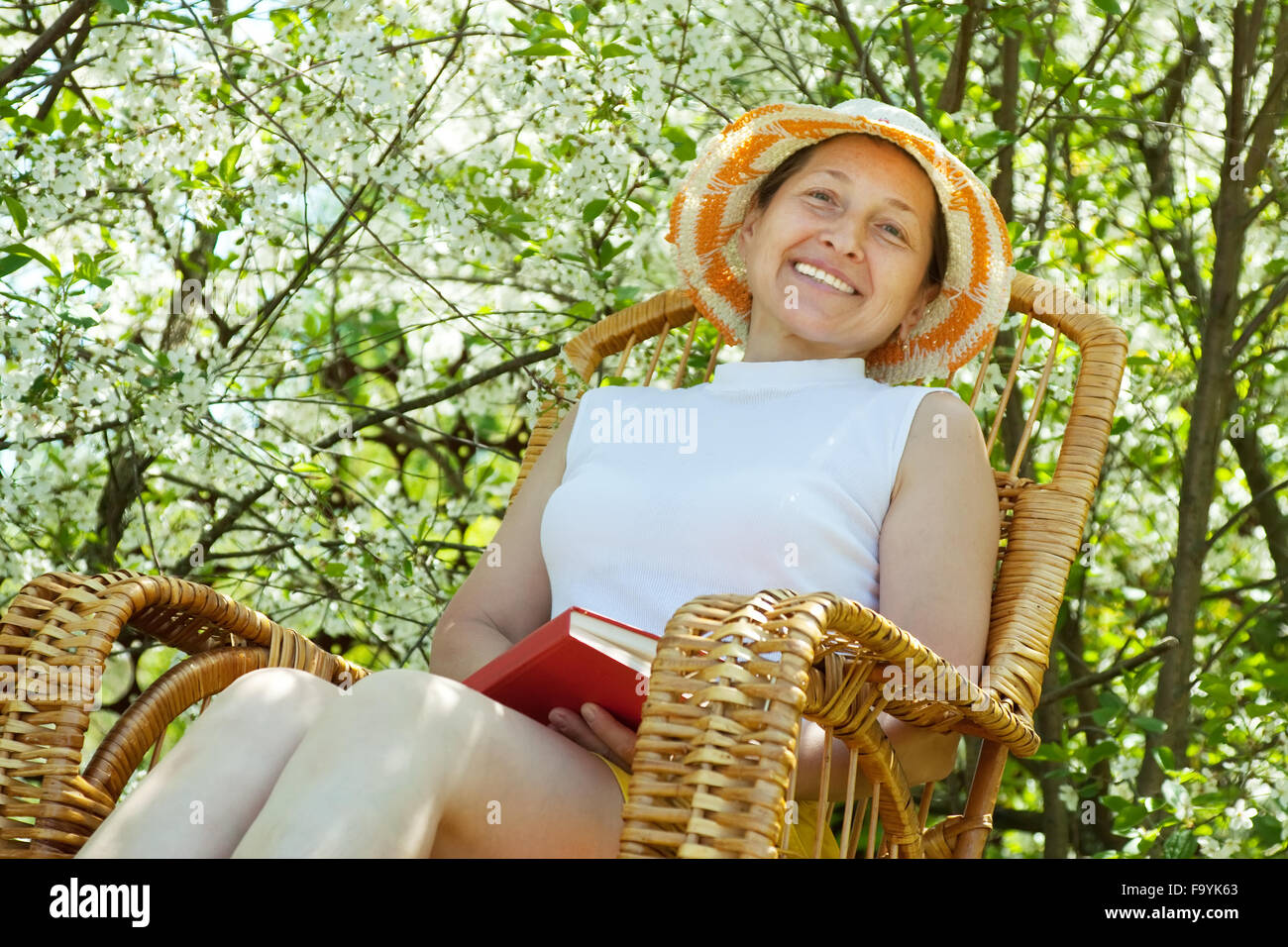Happy mature woman relaxing in bloom garden Stock Photo - Alamy