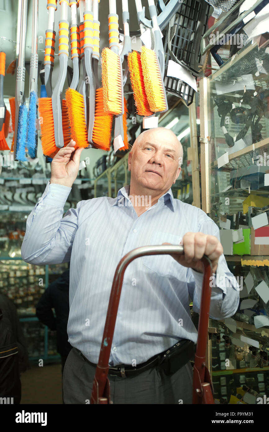 mature man chooses automotive broom in auto parts store Stock Photo Alamy