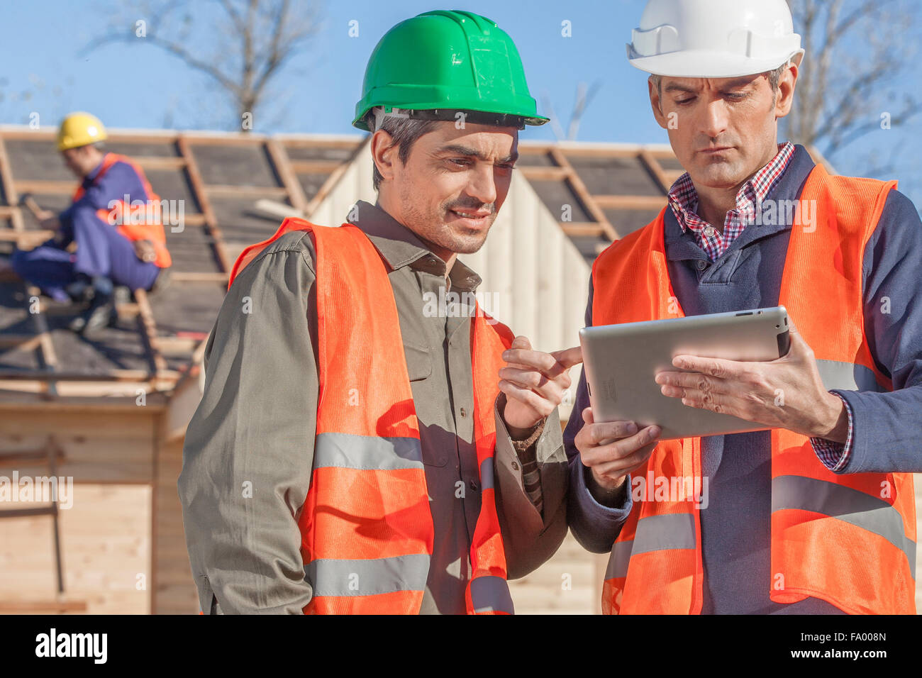 3 person construction crew standing in front of newly built house Stock Photo