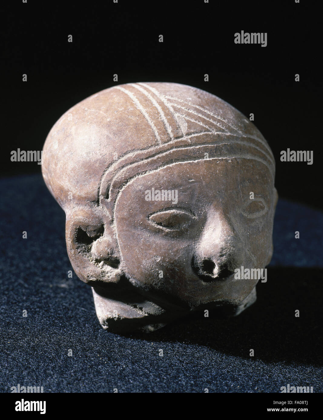 Pre-Columbian art. Pre-Incan. Guangala Culture.300/200 a 700/800 DC. Clay head with eyes and ornaments. Hair done with incisions. 5 x 5 cm. From Ecuador. Private collection. Stock Photo