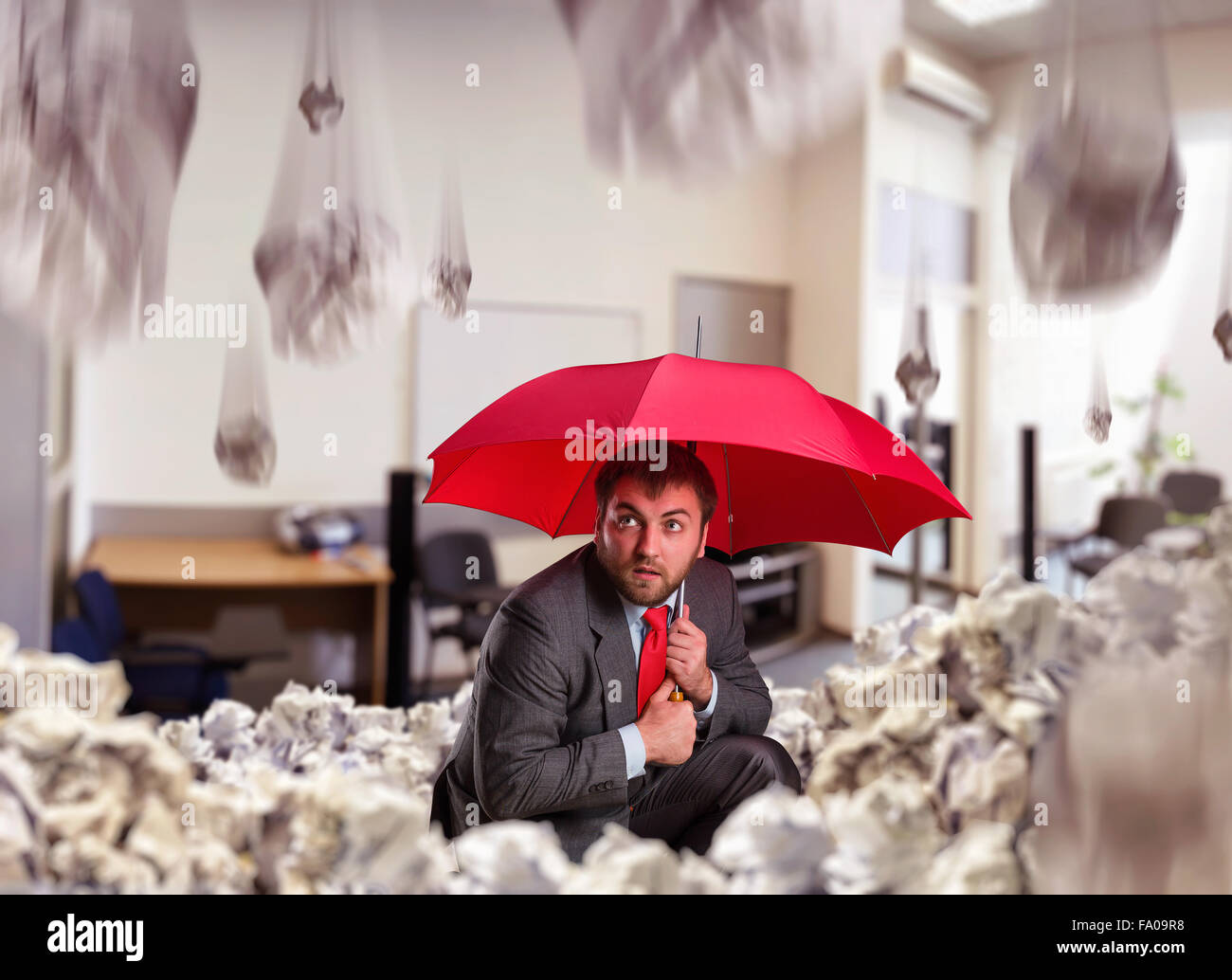 Businessman with umbrella in the office Stock Photo Alamy