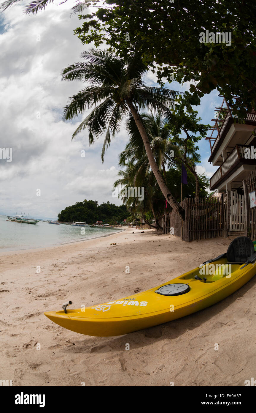 Yellow kayak laying on the sand beach with palm tree Stock Photo - Alamy