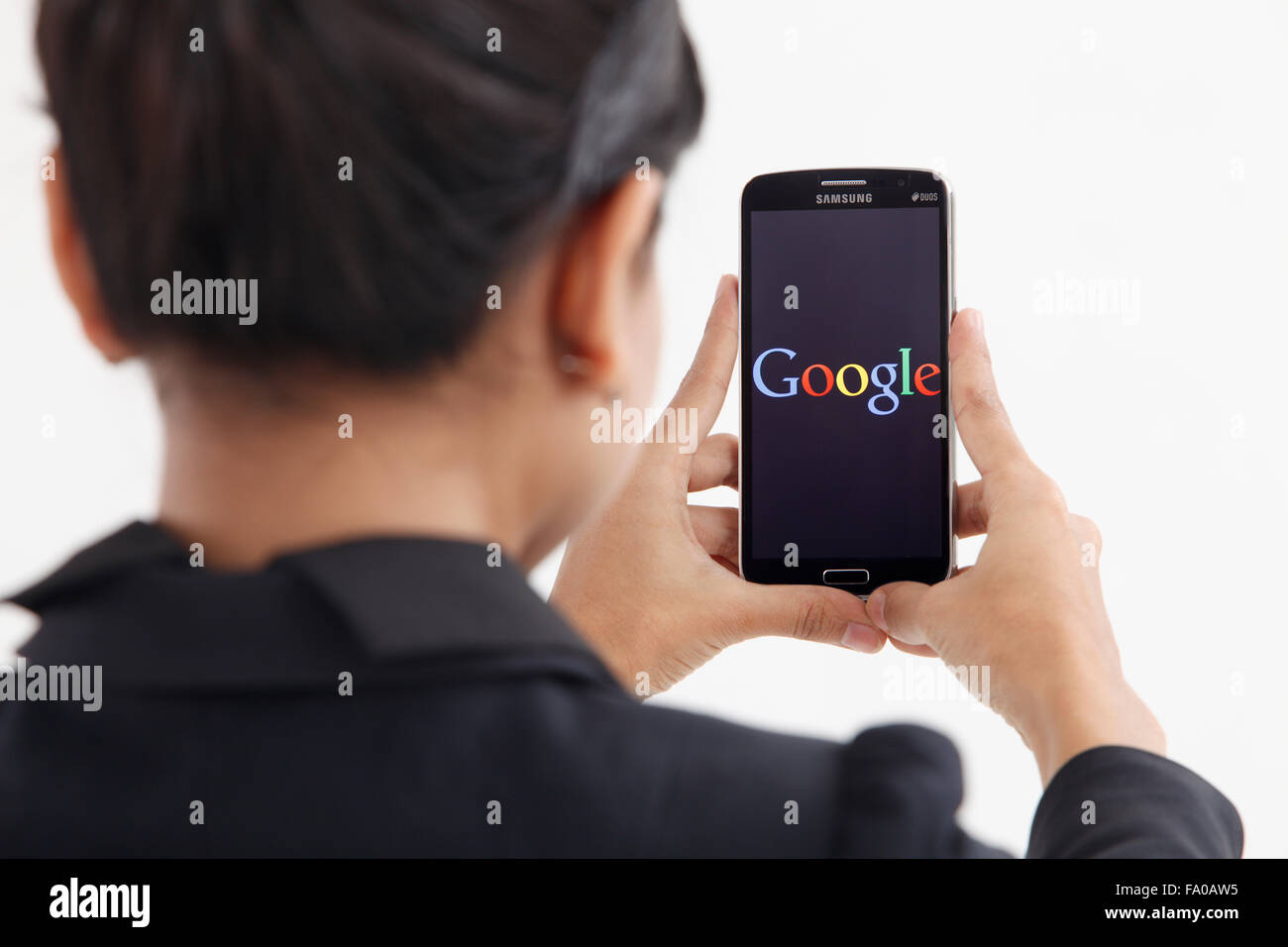 KUALA LUMPUR, MALAYSIA - 14th May 2015, woman using smart phone with the google logo on it Stock Photo