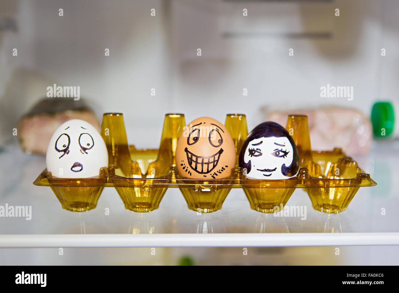 Two lovers eggs in the refrigerator and the third is a sad Stock Photo