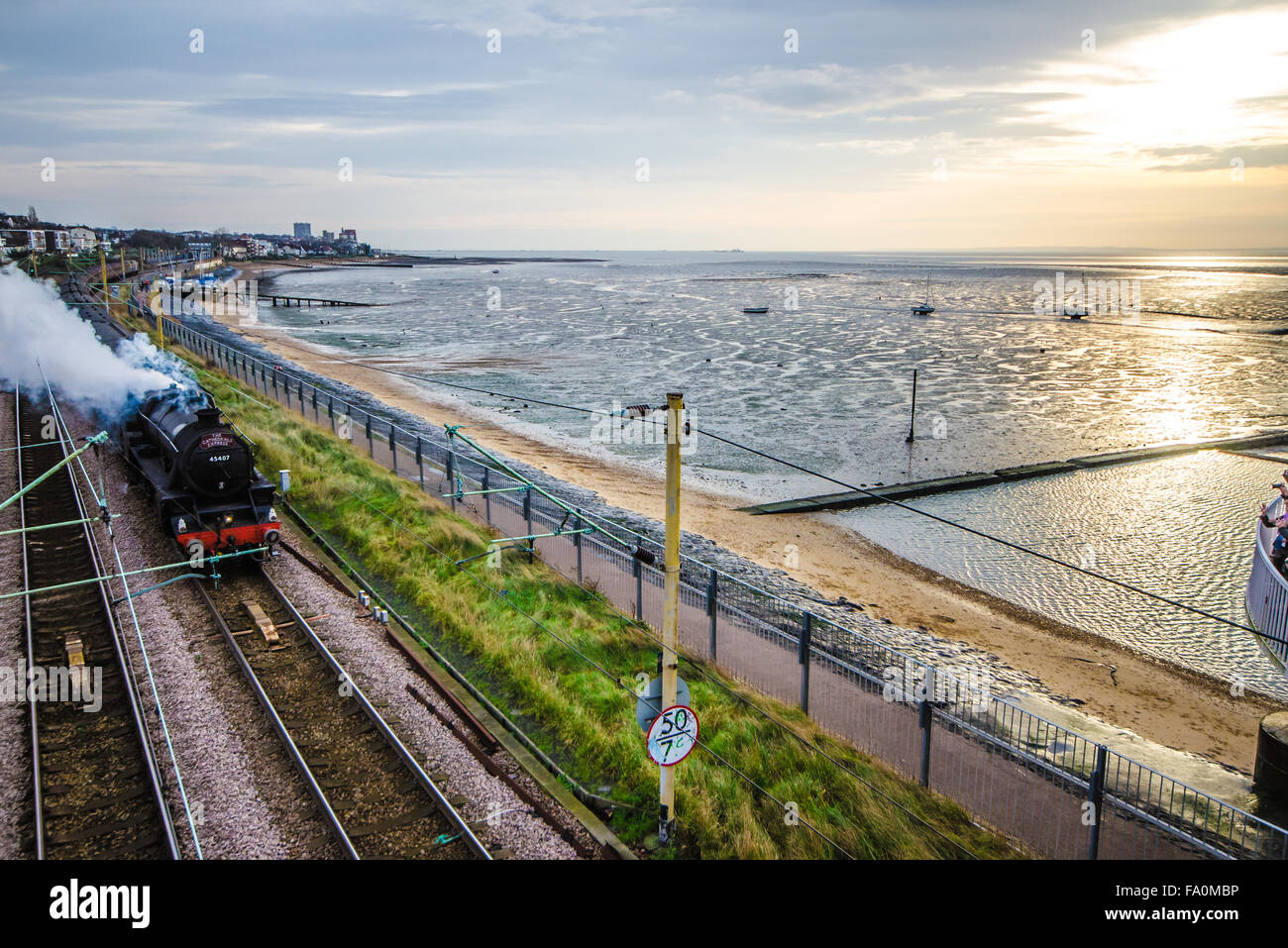 'The Cathedrals Express' - hauled by LMS Stanier Class 5 4-6-0 45407 'The Lancashire Fusilier' - 'Black 5'. Owned by railway engineering company Riley and Son. Seen here passing through Chalkwell along the Thames estuary at sunrise Stock Photo