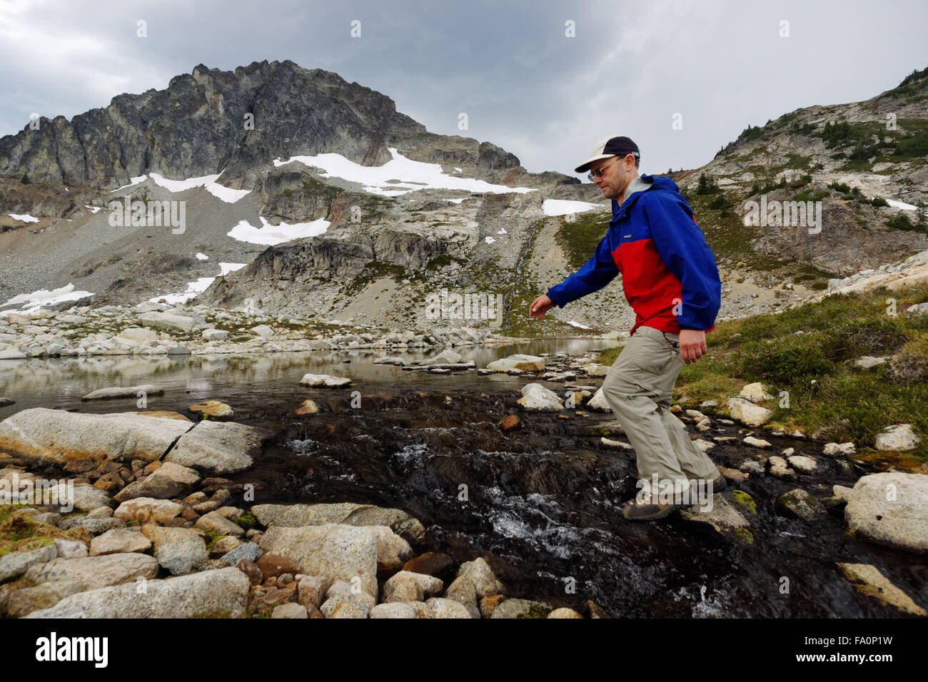 Man leaping stream, Silent Lakes, North Cascades National Park, Skagit County, Washington, USA Stock Photo