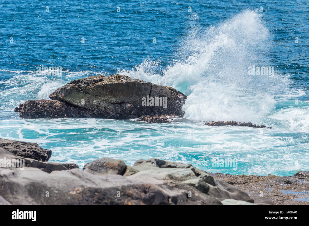 Sea spray of waves crashing against rocks.  Short Point Merimbula Stock Photo