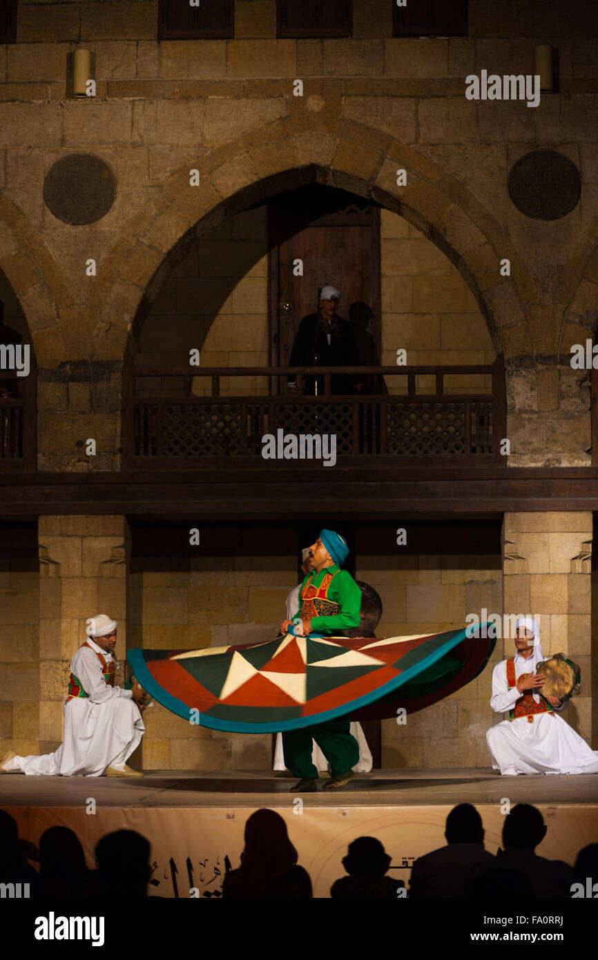 A Sufi dancer in green spinning his dress during a whirling dervish performance, a famous tourist attraction, at the Al Ghouri Stock Photo