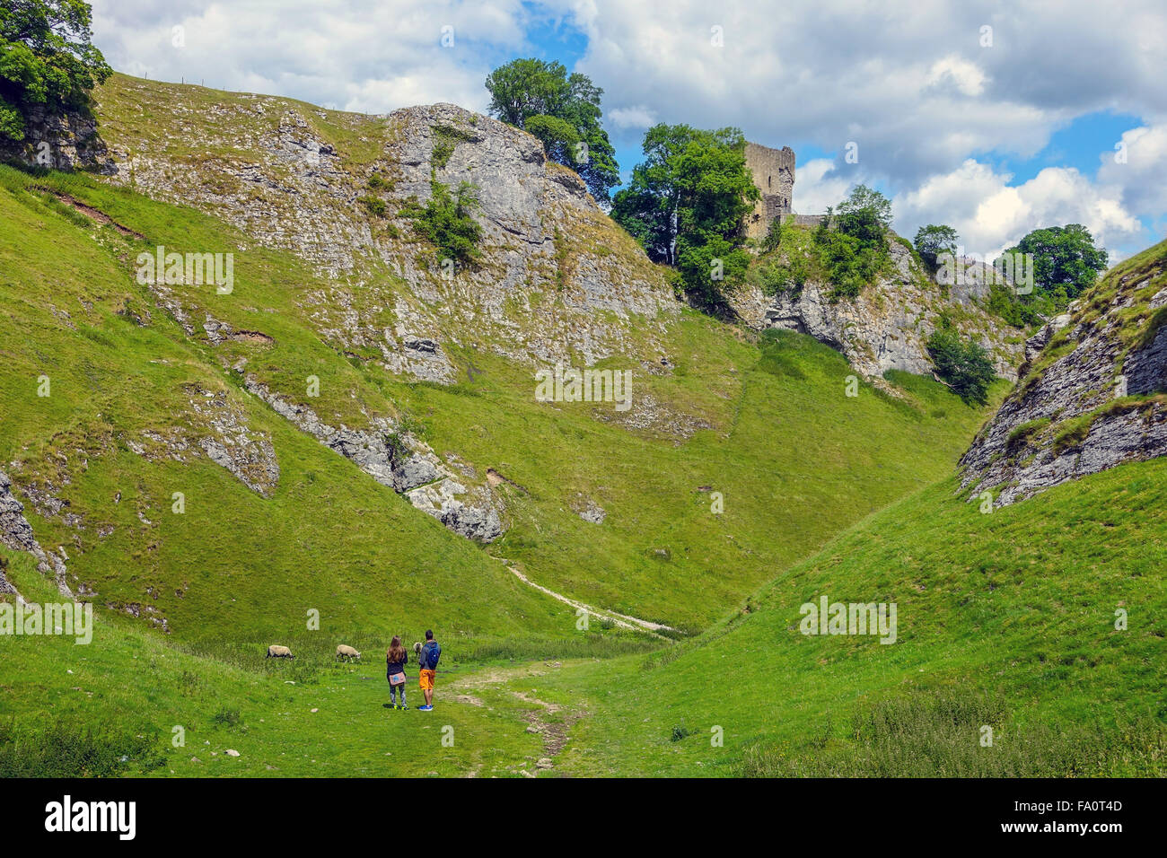 Two walkers hikers in Cavedale with Pevril Castle, Castleton Stock Photo