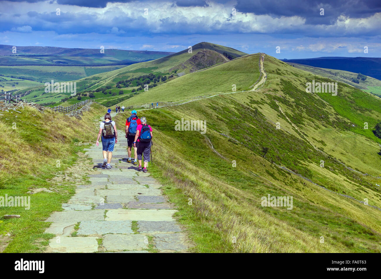 Hikers on the flagged footpath along the Great Ridge above Castleton, Peak District Derbyshire Stock Photo