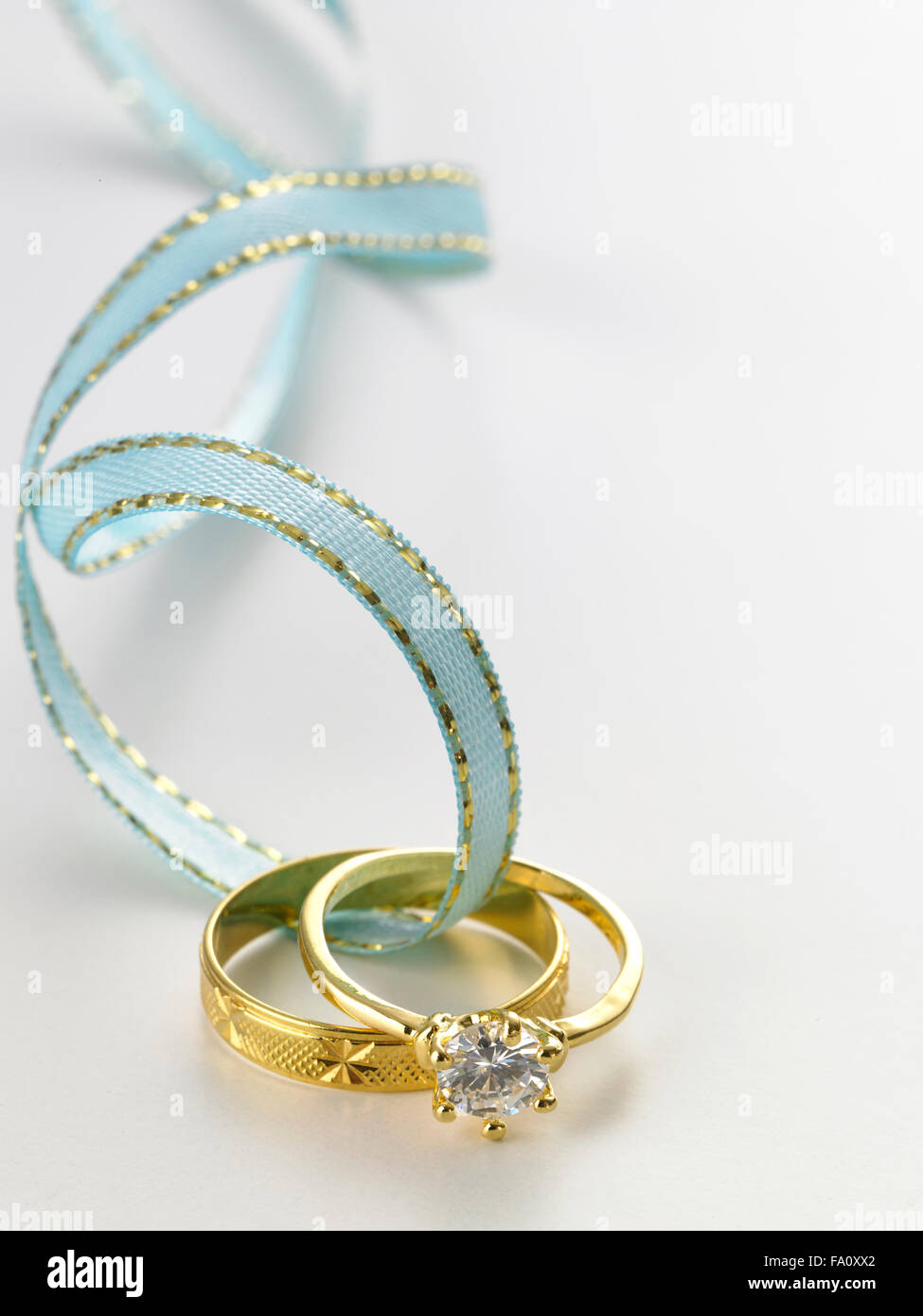 Wedding rings connected with green ribbon Stock Photo - Alamy