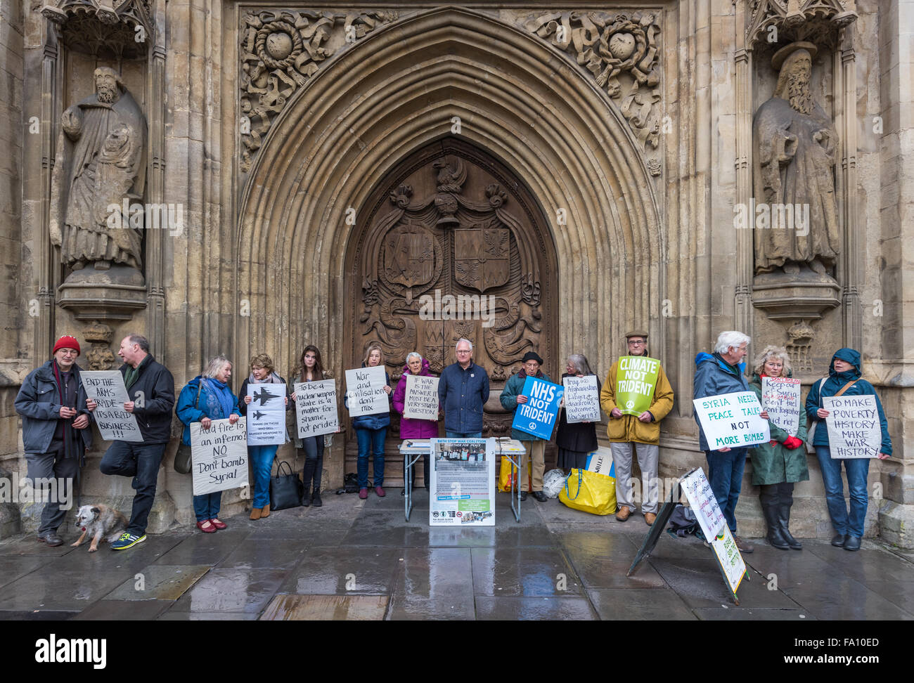 Bath, UK. 19th Dec, 2015. Heavy rain doesn't dampen the spirits of  the 'Bath Stop War Coalition', as they protest outside Bath Abbey, on the last weekend before Christmas. Credit:  Terry Mathews/Alamy Live News Stock Photo