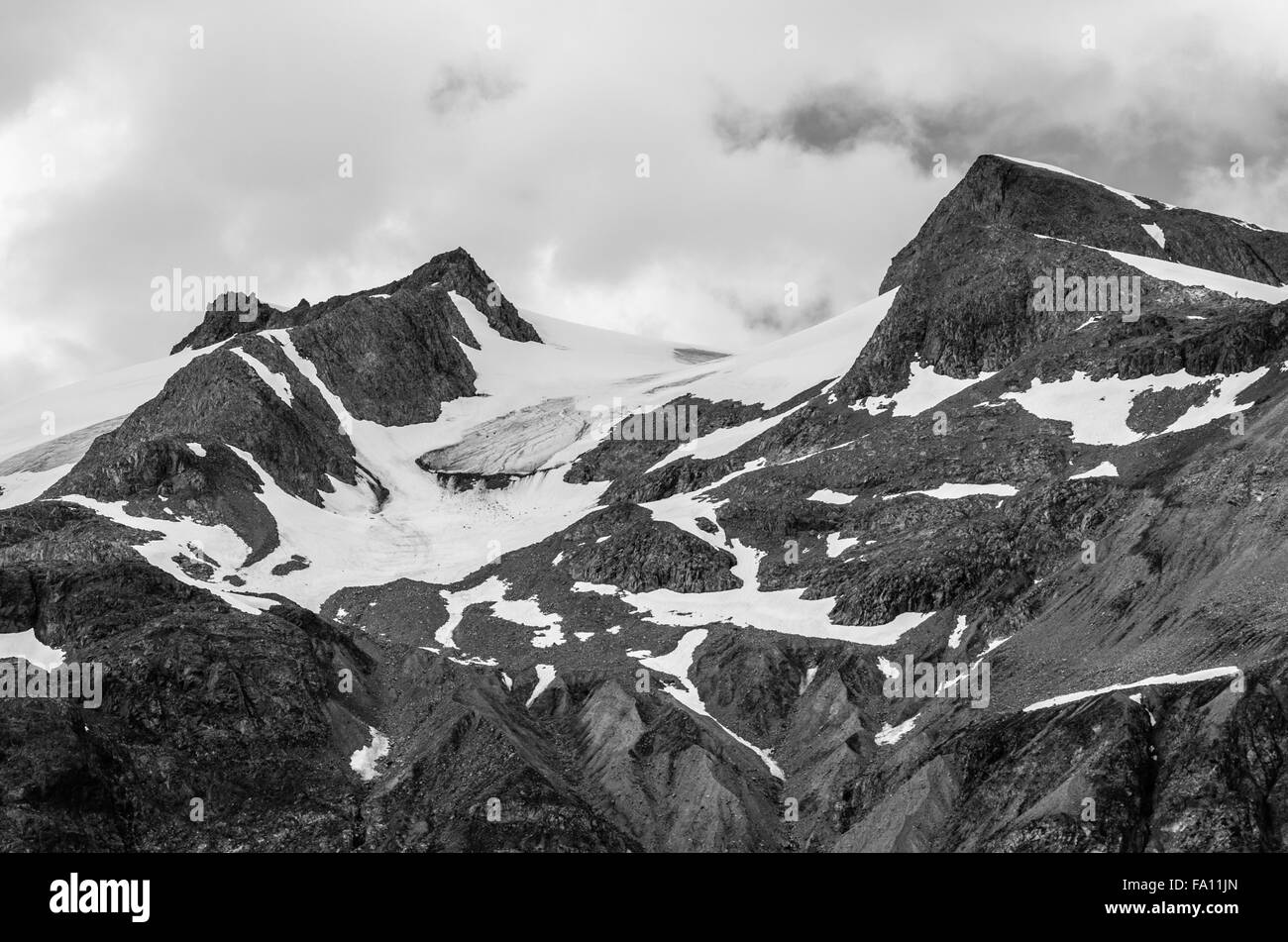 Snowy Mountain Tops And Moody Sky B & W In Glacier Bay National Park, Alaska Stock Photo