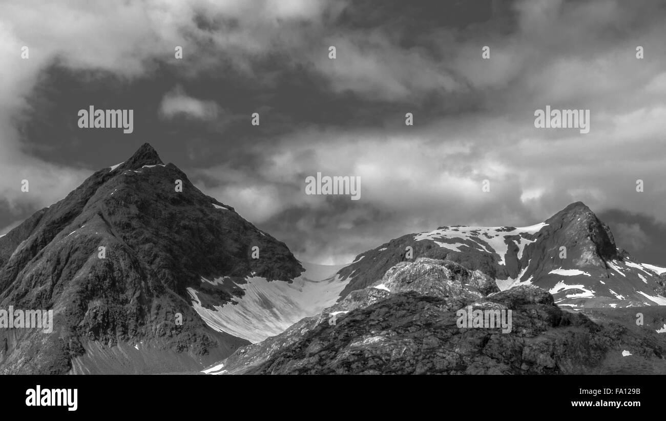 Mountain Tops, Snow, And Cloudy Sky In Alaska In Black & White Stock Photo
