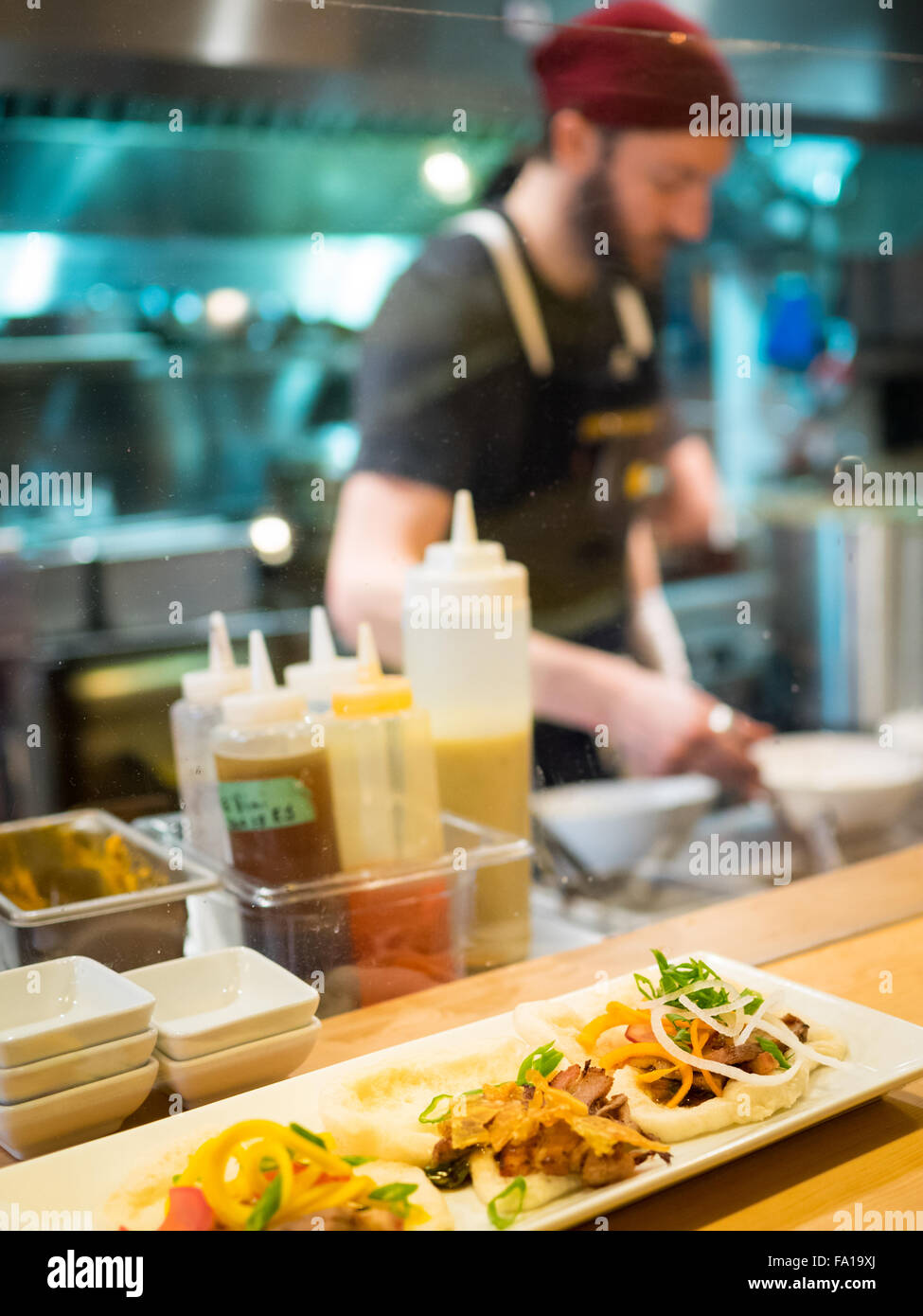 A chef engaged in food preparation at the Prairie Noodle Shop, a ramen restaurant in Edmonton, Alberta, Canada. Stock Photo